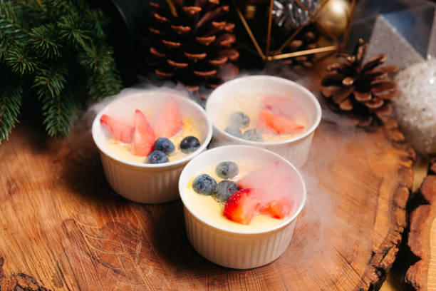 crema catalana com bagas silvestres nas nuvens de nitrogênio. sobremesa de creme da catalunha com vários tipos de bagas servidas de forma única usando nitrogênio para criar um efeito de nuvem. - custard creme brulee french cuisine crema catalana - fotografias e filmes do acervo