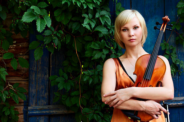 istock young woman holding a violin 174554808