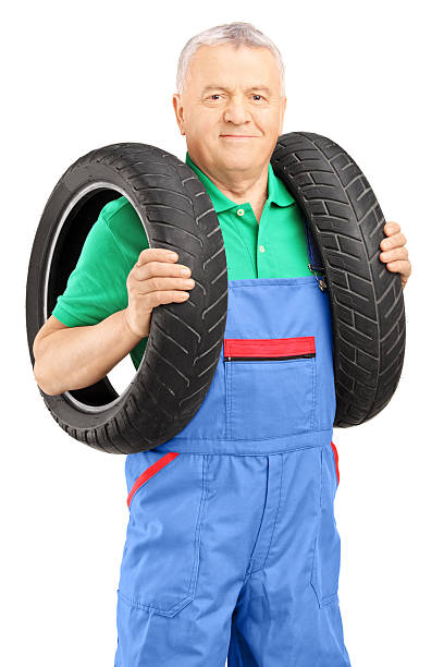 istock Mechanic holding a vehicle tires and looking at camera 174558046