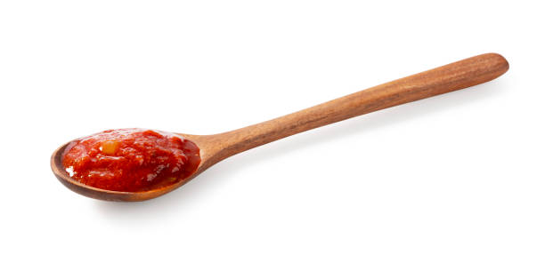 istock Wooden spoon and tomato sauce on white background. 1745611660