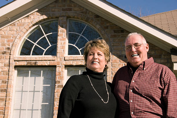 Senior Couple in front of house