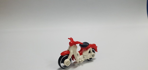 Red and white classic motorbike on a blurred white background