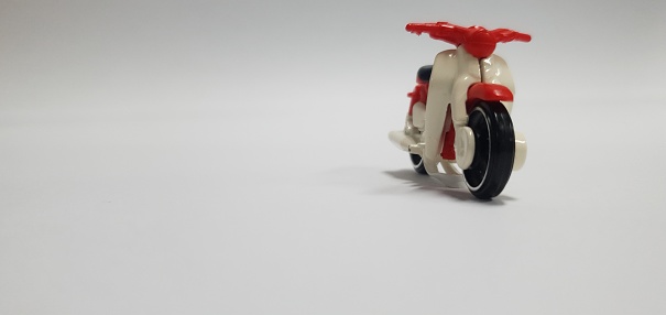 Red and white classic motorbike on a blurred white background