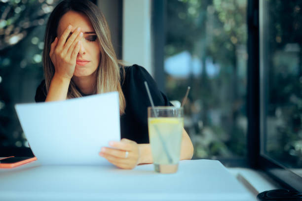 istock Unhappy Woman Sitting in a Restaurant Reading a Contract 1745626182