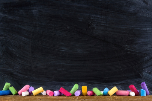 Black old empty chalkboard for copy space with colorful pieces of chalk