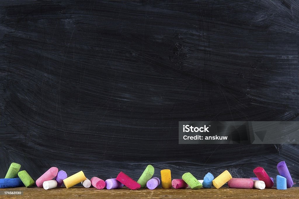 Black old empty chalkboard Black old empty chalkboard for copy space with colorful pieces of chalk Chalkboard - Visual Aid Stock Photo