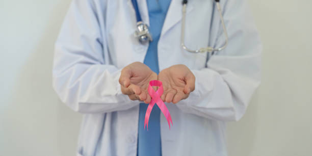 outubro rosa mês de conscientização do câncer de mama, médico com símbolo de fita rosa. mês nacional dos sobreviventes ao câncer. conceito de cuidado em saúde - breast cancer awareness ribbon breast cancer ribbon charity and relief work - fotografias e filmes do acervo