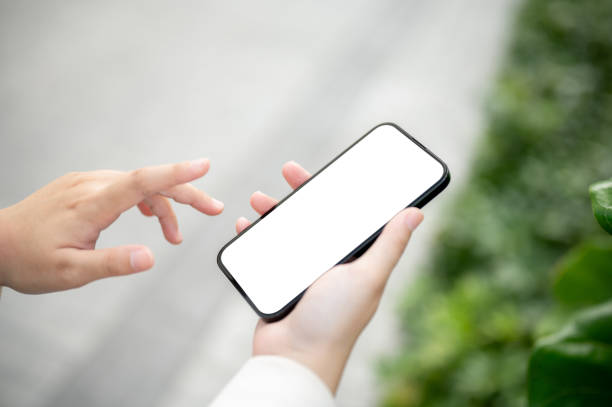 istock A woman using her smartphone while strolling in a park. A white-screen smartphone mockup 1745677405