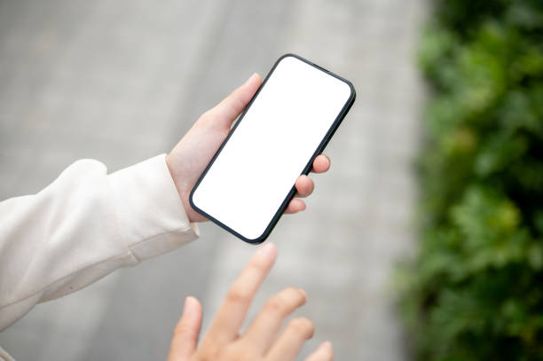 istock A woman using her smartphone while strolling in a park. A white-screen smartphone mockup 1745677988
