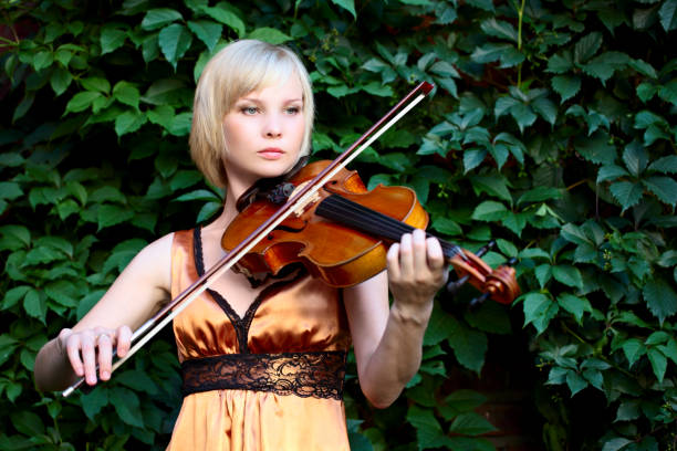 istock young woman holding a violin 174568512