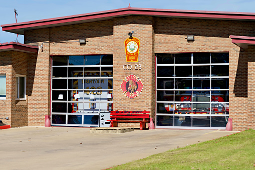 Annandale, Virginia, USA - October 19, 2023: Fire engines are seen behind the glass garage doors of Company 23, Annandale Volunteer Fire Department of the Fairfax County Fire Department.