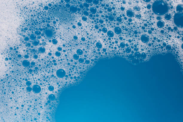 istock Detergent foam bubble on water. Blue background, Soap sud 1745700367