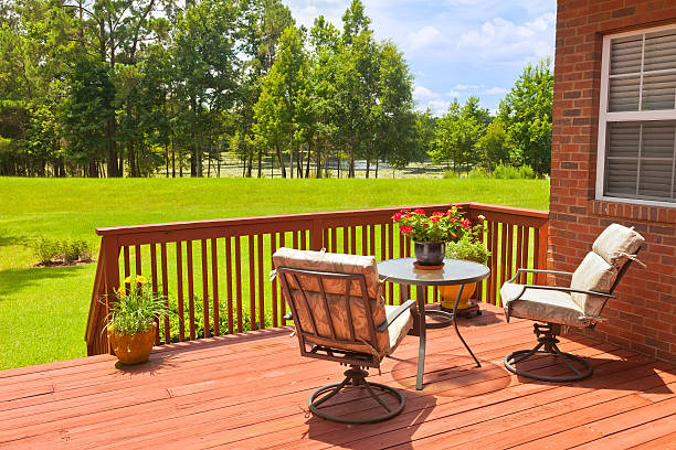 Backyard deck next to a green field Residential backyard deck overlooking lawn and lake house railing stock pictures, royalty-free photos & images