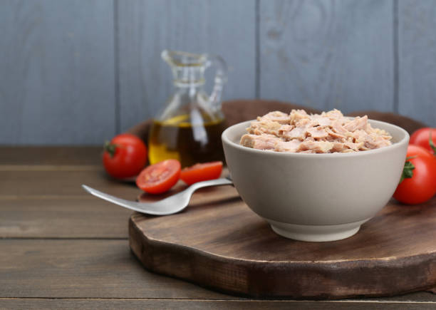 istock Bowl with canned tuna and tomatoes on wooden table, space for text 1745757708