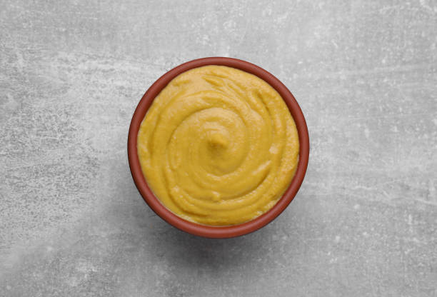 istock Bowl with delicious mustard on light grey table, top view 1745759838
