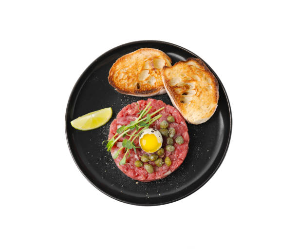 saboroso steak steak tartare servido com ovo de codorna, pão torrado e outros acompanhamentos isolados no branco, vista superior - accompaniments - fotografias e filmes do acervo