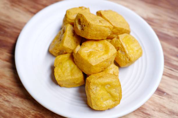 istock Delicious fried tofu served on white plate on wooden background 1745762021