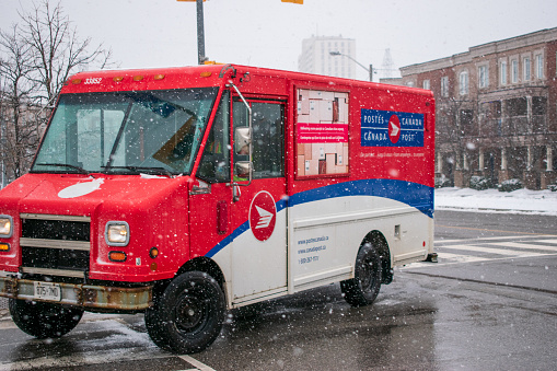 Toronto, Ontario , Canada - January 03, 2021: Canada Post truck delivering mail in Winter