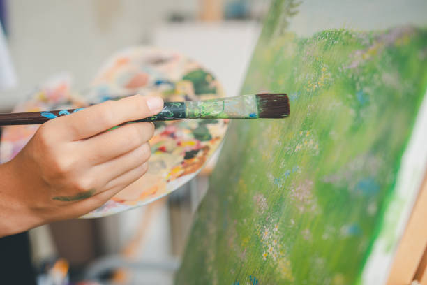 istock close-up art student's hand using watercolor paint brush painting on canvas doing some art projects on studio workshop 1745766277