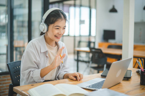 Teenage Asian students wearing a headphone are communicating through video conferencing for online learning. In a video conference call via apps. Teenage Asian students wearing a headphone are communicating through video conferencing for online learning. In a video Teenage Asian students wearing a headphone are communicating through video conferencing for online learning. In a video conference call via apps. online tutors stock pictures, royalty-free photos & images