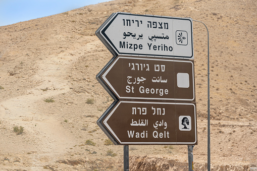 Directional sign in the Judean desert to Mitzpe Yeriho, a religious Israeli settlement in the West Bank, Saint George, a Greek orthodox monastery, and Wadi Qelt, a stream in the West Bank