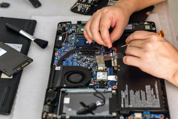 istock computer technician laptop motherboard repair technician Removing the battery cable connector from the notebook computer motherboard. 1745775431