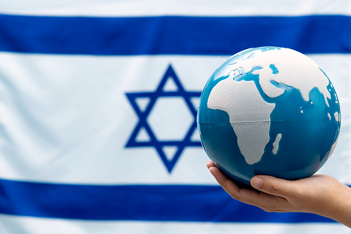World globe in front of Israeli flag.