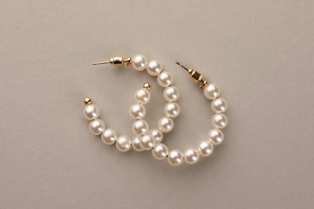 istock Elegant earrings with pearls on beige background, top view 1745831383