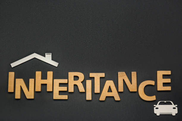 istock Word Inheritance made with wooden letters and different cutouts on black background, flat lay. Space for text 1745833963