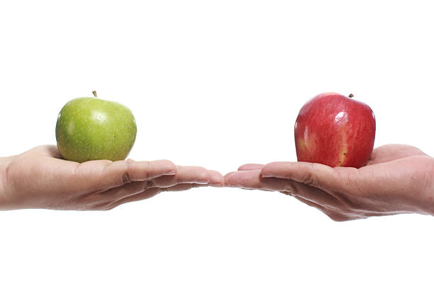 istock Two Hands holding red and green apples 174583575