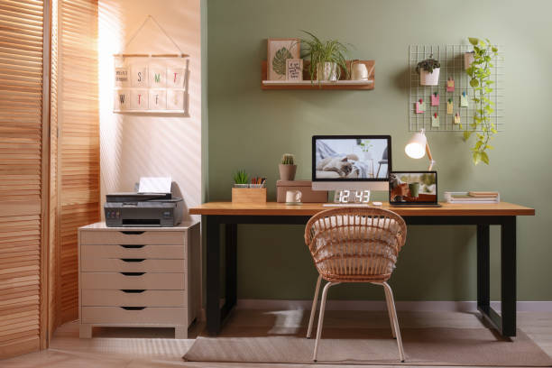 istock Stylish workplace with computer, laptop and lamp near olive wall at home 1745838358