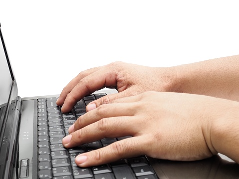 Human hands sitting in the workplace on a white work desk and typing on the keyboard of a laptop computer.  business idea  Isolated on a white background.