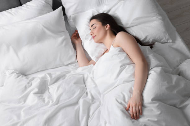 istock Beautiful young woman sleeping in soft bed, above view 1745861886