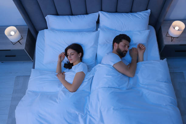 istock Lovely couple sleeping together in bed at night, top view 1745862731