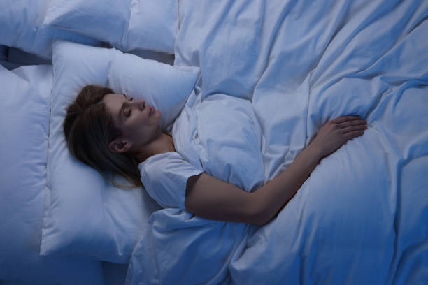 istock Woman sleeping in bed at night, above view 1745864369