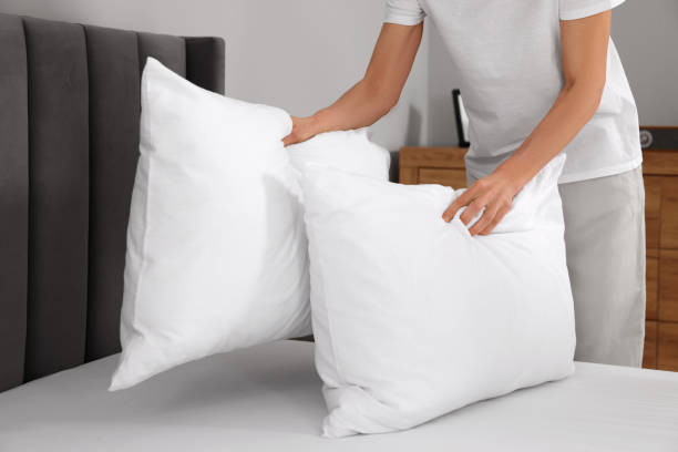 istock Woman putting pillows on bed at home, closeup. Space for text 1745865418