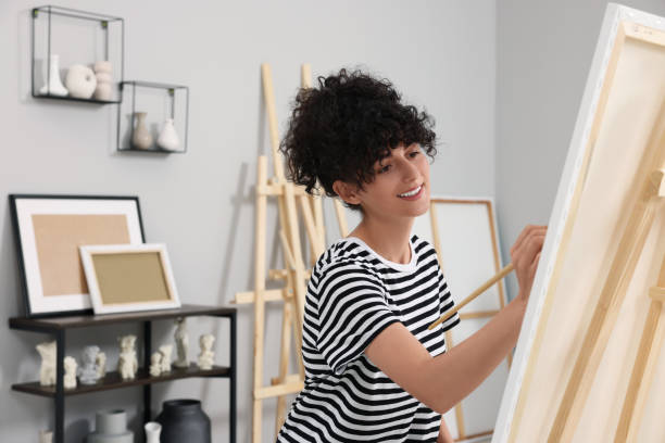 istock Young woman painting on easel with canvas in studio 1745882765