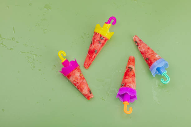 istock Frozen watermelon popsicles on trendy Savannah green background. Refreshing summer dessert 1745891779