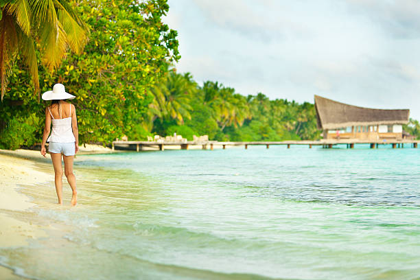 Female walking on the beach stock photo