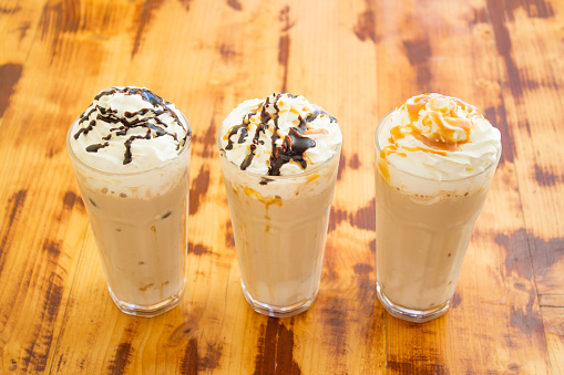 Three frappes on wooden table. Close-up shot, High Angle View.