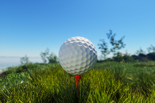 Close-up View Of Golf Ball On Tee In Golf Course With Blurred Background