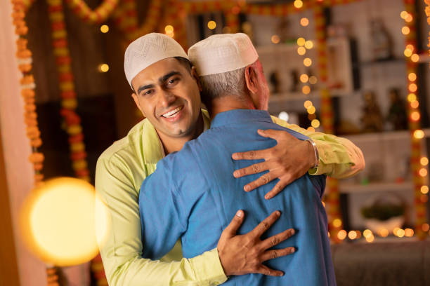Father and son in skull caps embracing during Eid-Ul-Fitr