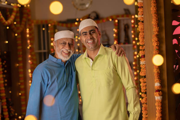 istock Father and son in kurta and skull caps at illuminated home 1745950669