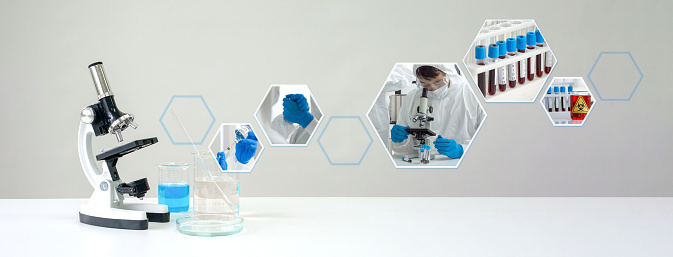 Microscope and blue chemical  liquid in beaker on white laboratory table, showing atmosphere of antiviral drug research in the laboratory.