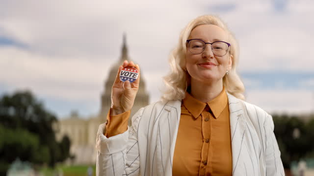 Happy woman showing vote button against US government building background