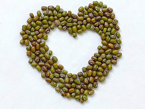 Mung beans placed in heart shaped on a white background. Mung beans help nourish energy and relieve beriberi. Close -up shot of the heart.