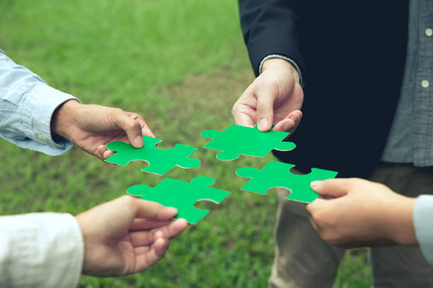 csr, responsabilità sociale d'impresa. il team aziendale che mette insieme il puzzle verde per il team. beneficenza, volontariato. unità, csr ambientale concetto di responsabilità sociale d'impresa. criteri esg (t - strategia dimpresa foto e immagini stock