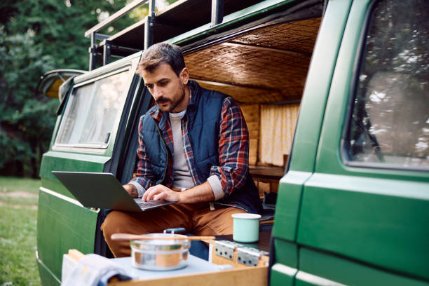 istock Male camper using laptop during a picnic at trailer park. 1745999527