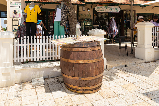 Zikhron Yaakov, Israel, July 08, 2023 : Big old wooden wine barrel stands on the main pedestrian HaMeyasdim street in Zikhron Yaakov city in northern Israel