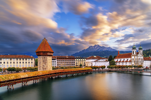 Lucern, Switzerland with the Chapel Bridge over the River Reuss with Mt. Pilatus in the distance at dusk.